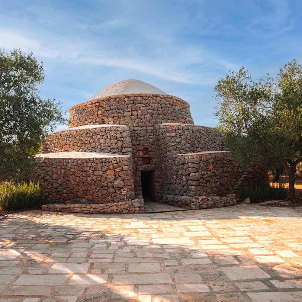 Trullo in pietra circondato dagli ulivi